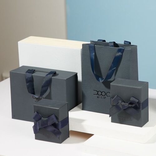 emballage personalisee Coffrets d'emballage cadeaux gris et noirs avec rubans, de différentes tailles.