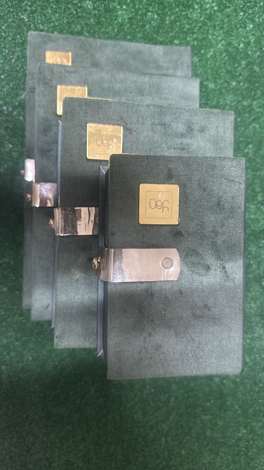 Petit coffret cadeau élégant en velours vert avec fermoir doré, vue de dessus.